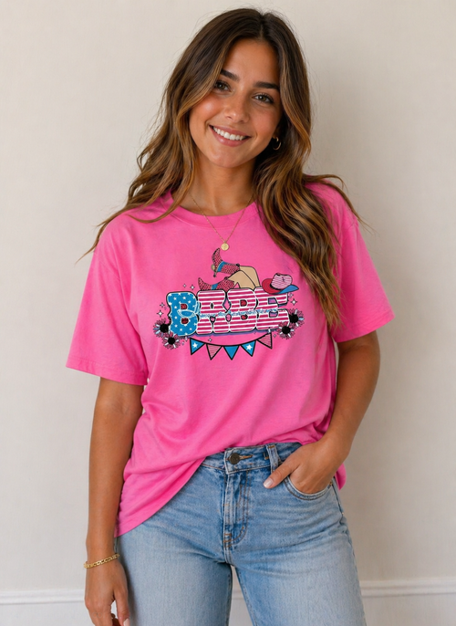 Woman wearing a pink t-shirt with a graphic design on a plain background